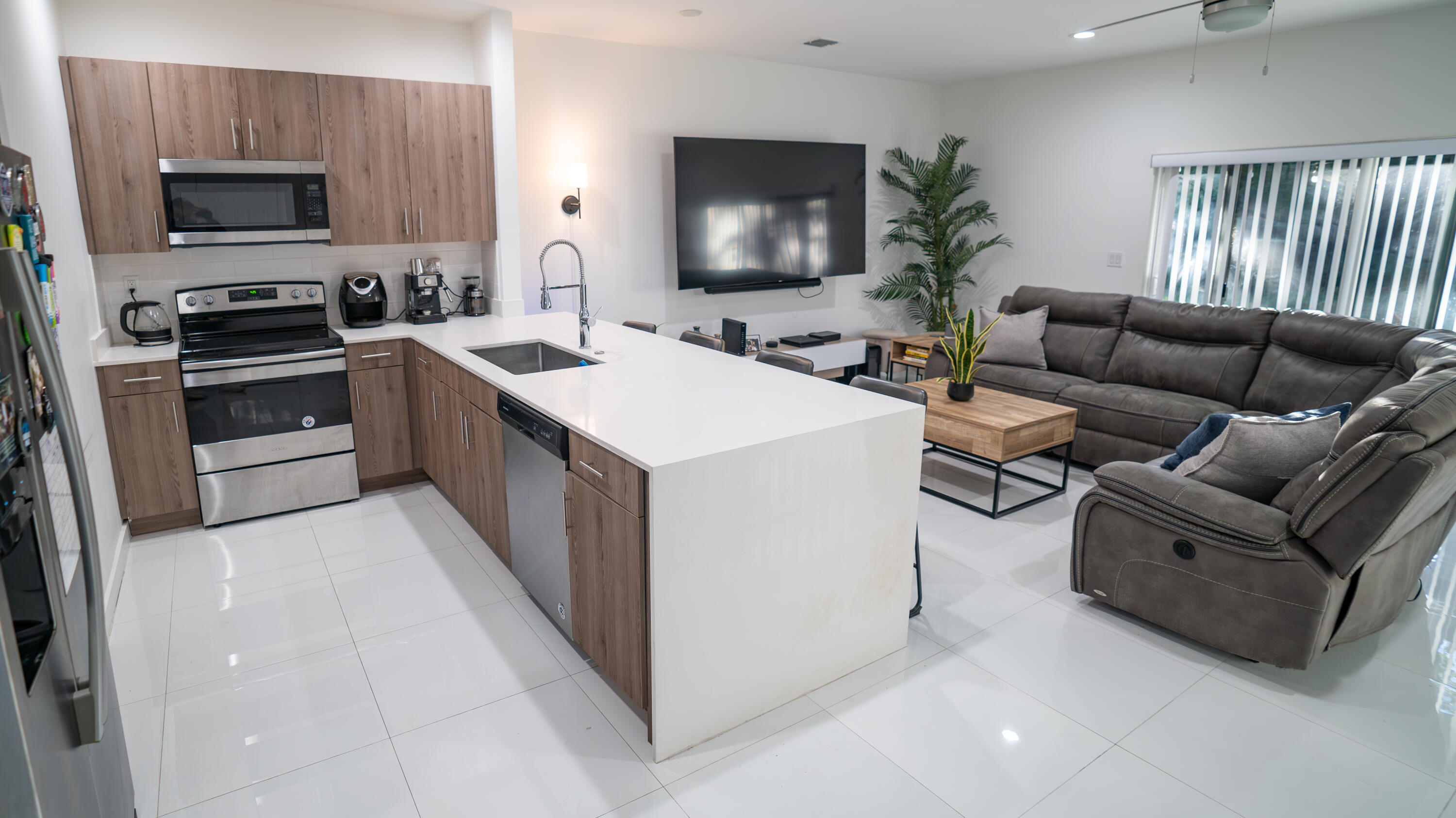 1330 Crystal Way, Unit 107 Delray Beach, FL 33444 - Photo 1 of 23 a living room with stainless steel appliances furniture a flat screen tv and a window