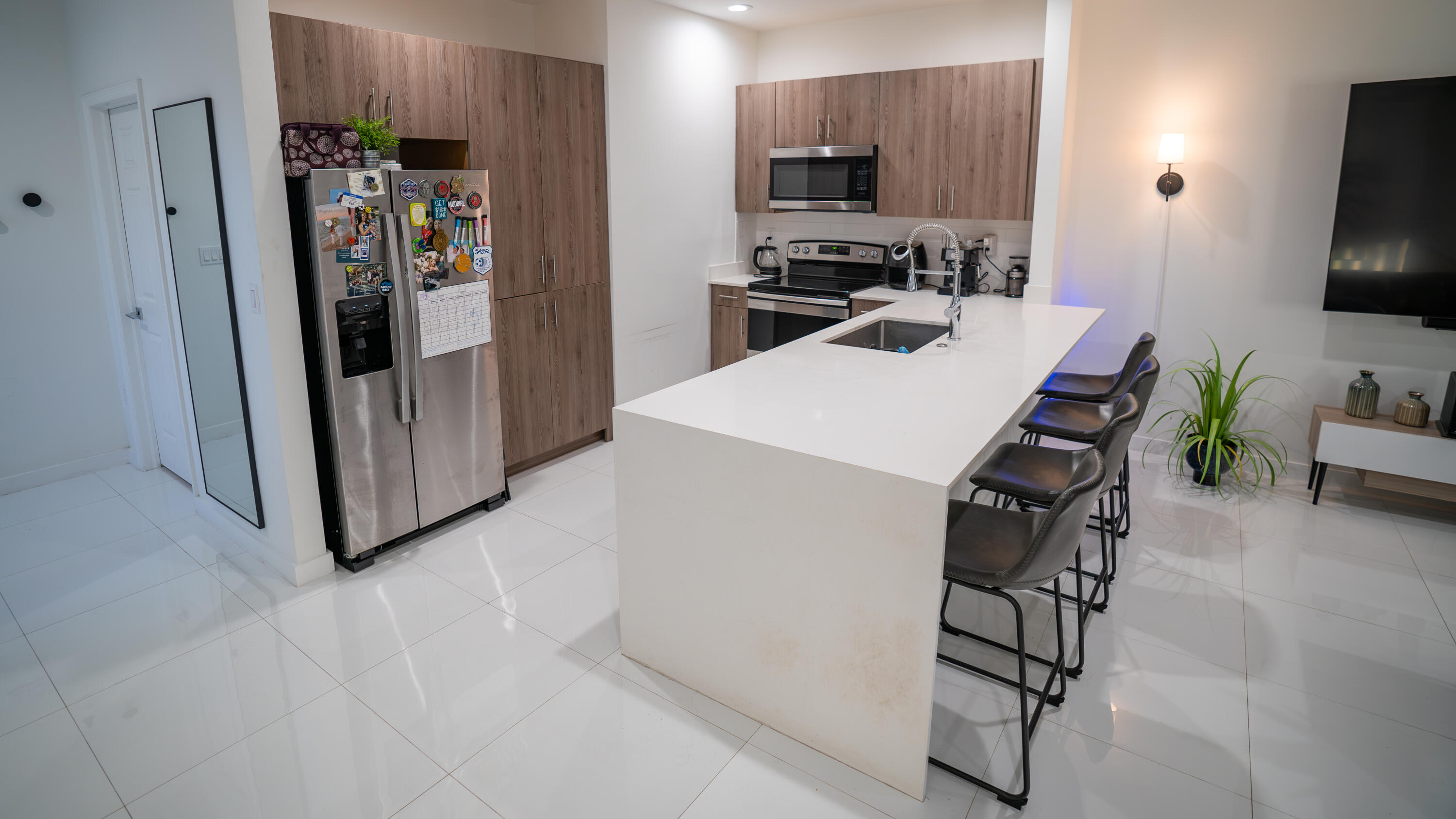 1330 Crystal Way, Unit 107 Delray Beach, FL 33444 - Photo 3 of 23 a kitchen with stainless steel appliances a refrigerator and a stove top oven