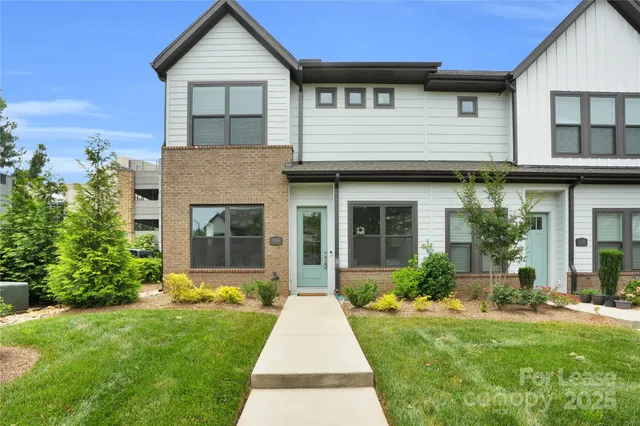 a front view of a house with a yard and potted plants