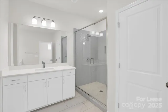 a bathroom with a shower sink and mirror