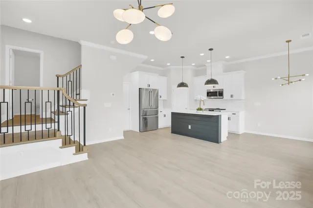 a large white kitchen with a refrigerator a sink and a stove