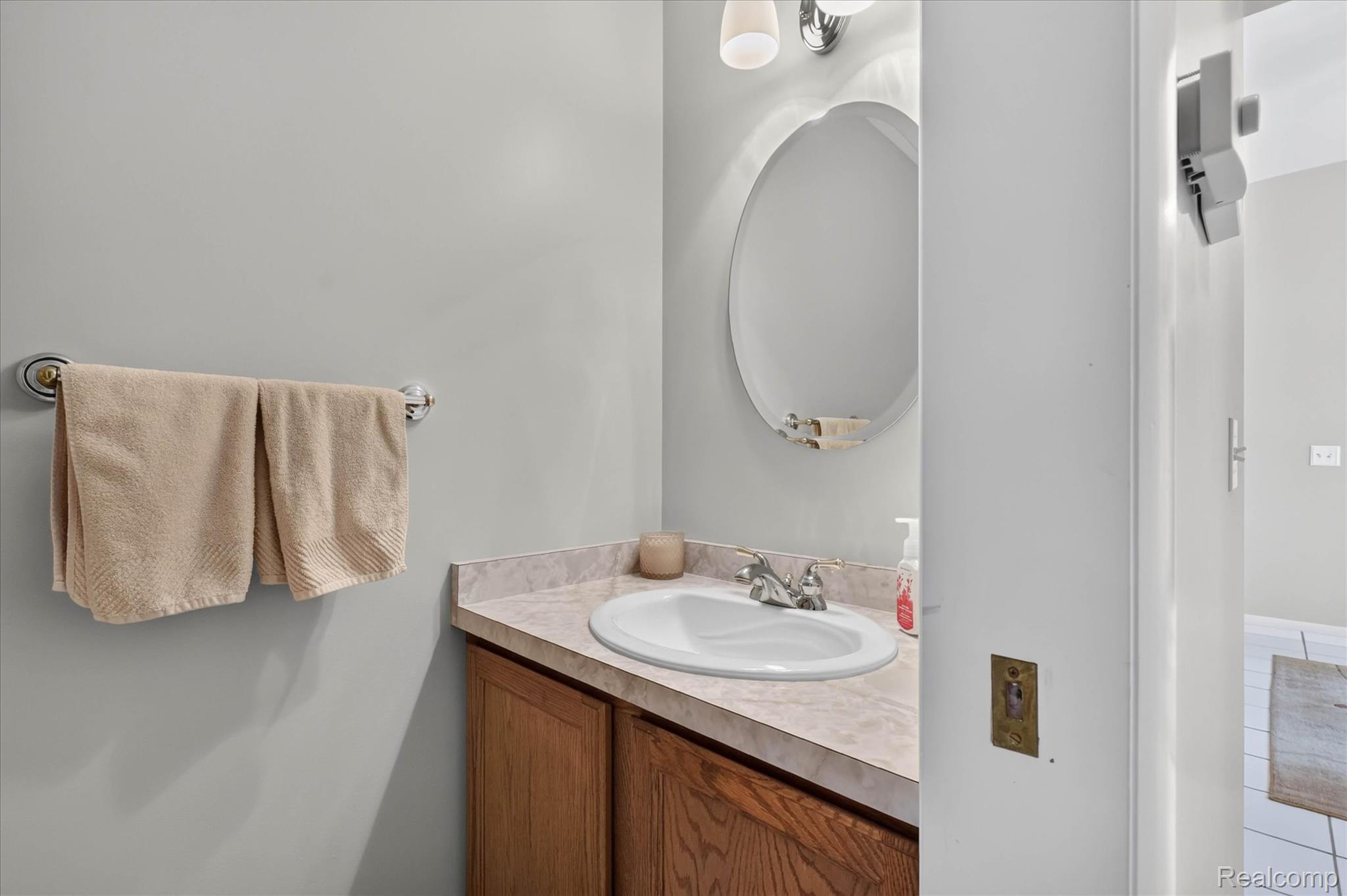 4037 Chilson Road Howell, MI 48843 - Photo 39 of 69 Oval vanity mirror with sconce lighting above