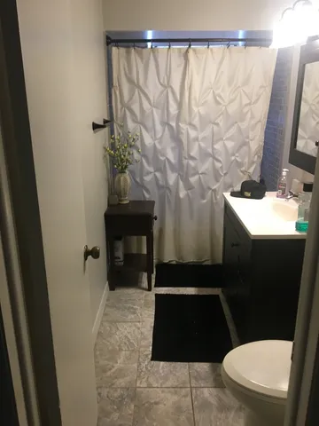a bathroom with a toilet and a shower curtain