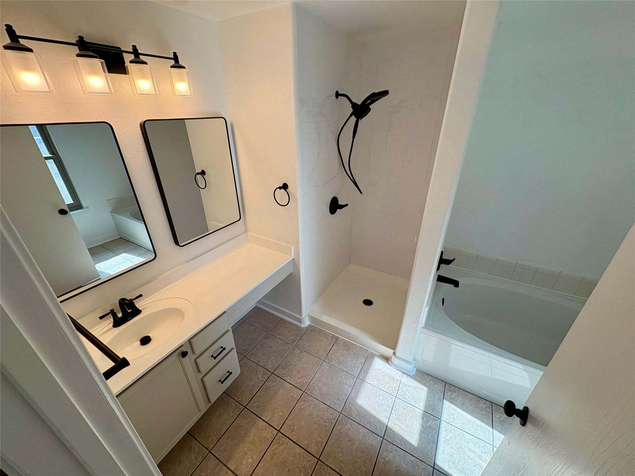 8003 Bannock Lane Austin, TX 78747 - Photo 21 of 40 Master bathroom with vanity, a shower stall, a bath, and light tile patterned flooring