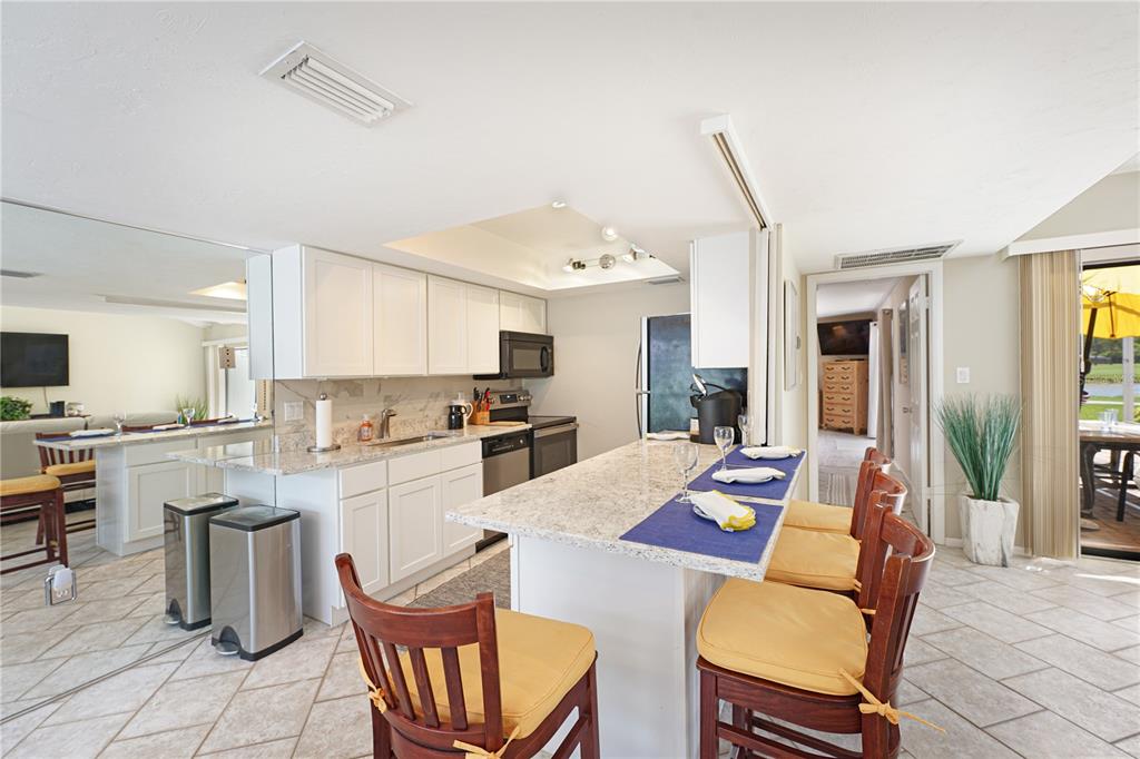 5903 43rd Street West, Unit 5903 Bradenton, FL 34210 - Photo 4 of 12 a kitchen with white cabinets and stainless steel appliances
