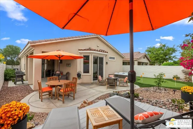 a view of a patio with table and chairs under an umbrella