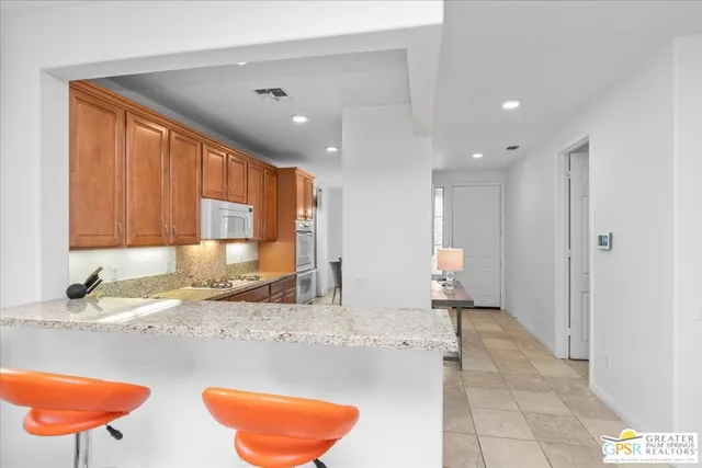 a view of a kitchen with granite countertop a refrigerator and a sink