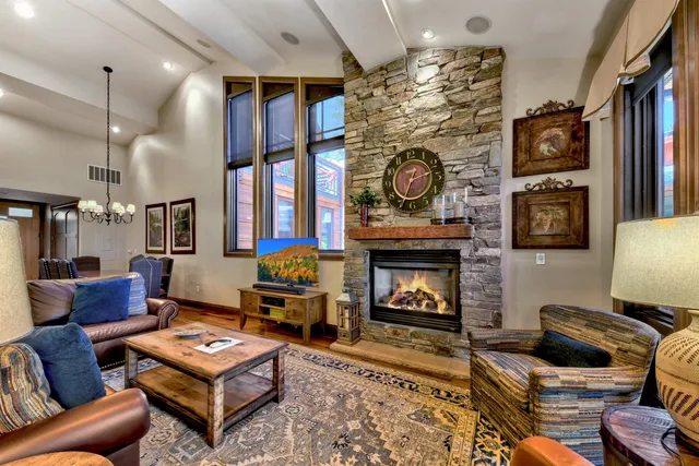a dining room with stainless steel appliances kitchen island granite countertop a table chairs and a refrigerator