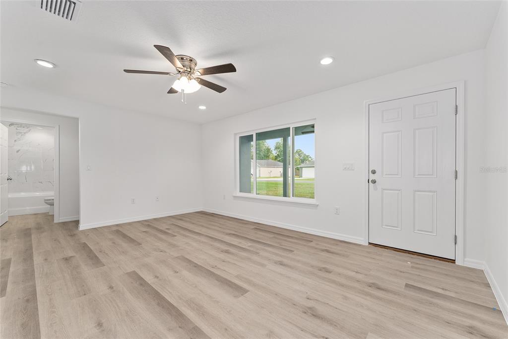 13119 Northeast 7th Loop Silver Springs, FL 34488 - Photo 12 of 51 wooden floor in an empty room with a window
