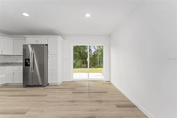 a view of empty room with wooden floor and window