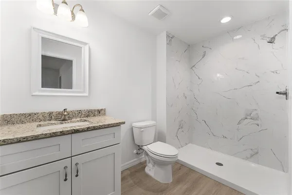 a bathroom with a granite countertop toilet a sink and a bathtub