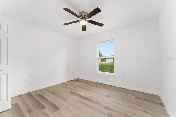 an empty room with closet and a chandelier fan