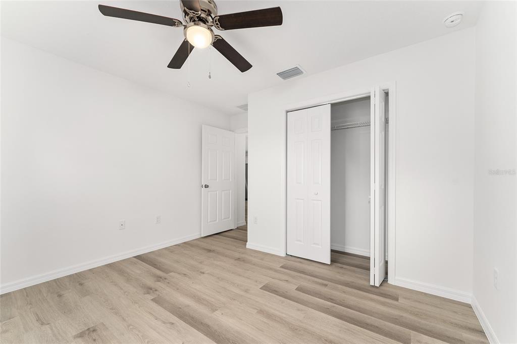 13119 Northeast 7th Loop Silver Springs, FL 34488 - Photo 38 of 51 an empty room with closet and a chandelier fan