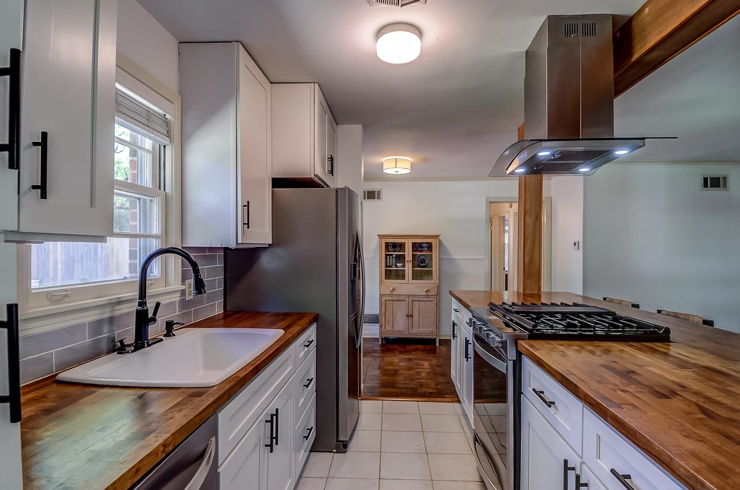 5056 Wingdale Road Memphis, TN 38117 - Photo 11 of 18 Kitchen with butcher block countertops, stainless steel appliances, island exhaust hood, and white cabinets