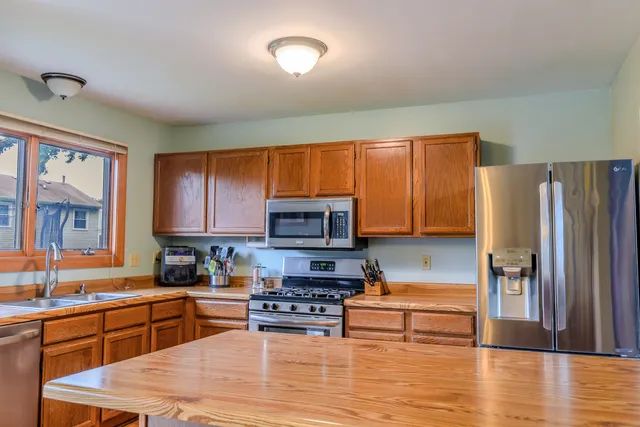 a kitchen with stainless steel appliances granite countertop a refrigerator stove top oven a sink and dishwasher