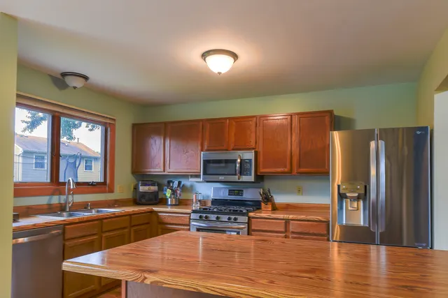 a kitchen with stainless steel appliances granite countertop a refrigerator stove microwave and sink