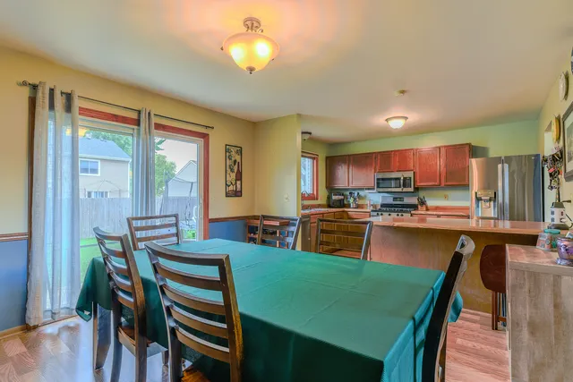 a kitchen with a table chairs refrigerator and cabinets