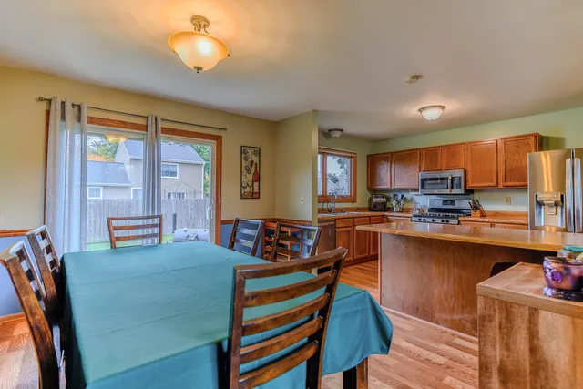 a kitchen with sink refrigerator dining table and chairs