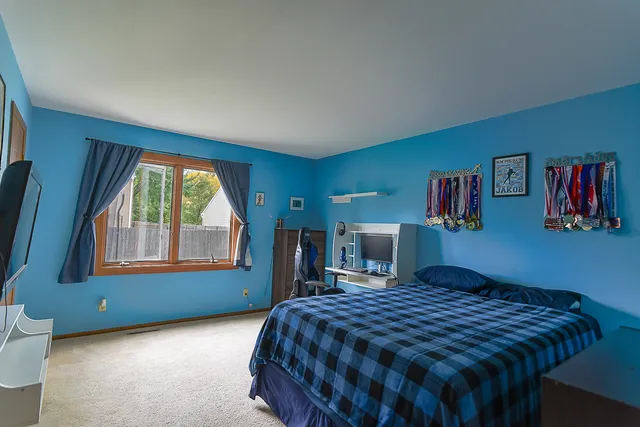 a bedroom with a bed and a large window