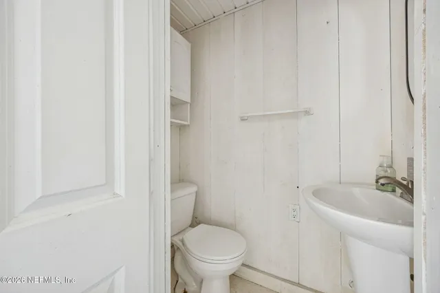 a living room with a black white checkered floor with a dining table and a chandelier