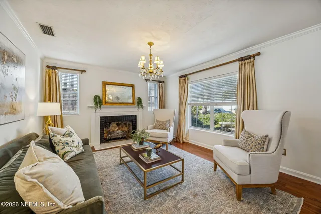a living room with furniture a fireplace and a chandelier