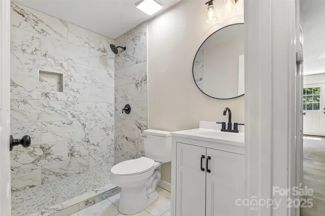 a bathroom with a sink a toilet and shower