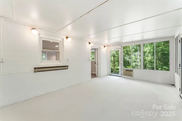 a view of a big room with windows and chandelier fan