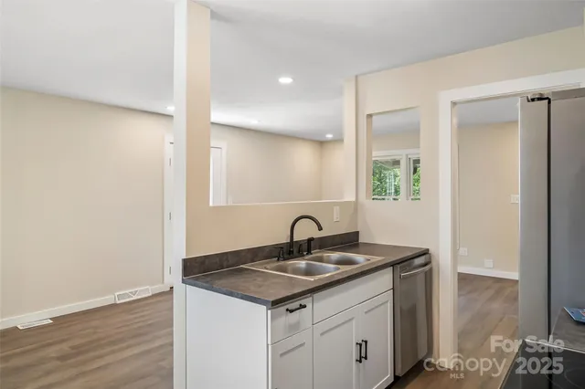 a kitchen with a sink cabinets and wooden floor