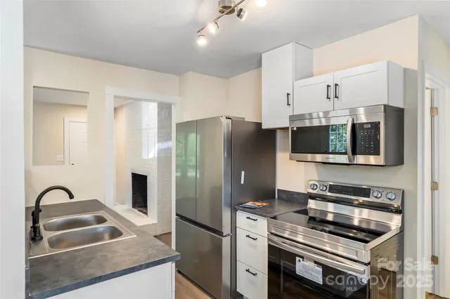 a kitchen with stainless steel appliances a stove a sink a microwave and refrigerator