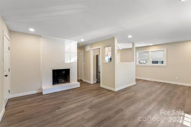 a view of a livingroom with wooden floor and fireplace