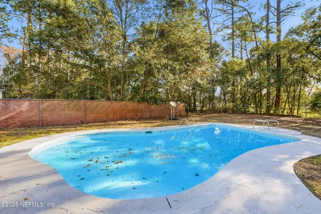 swimming pool view with a seating space
