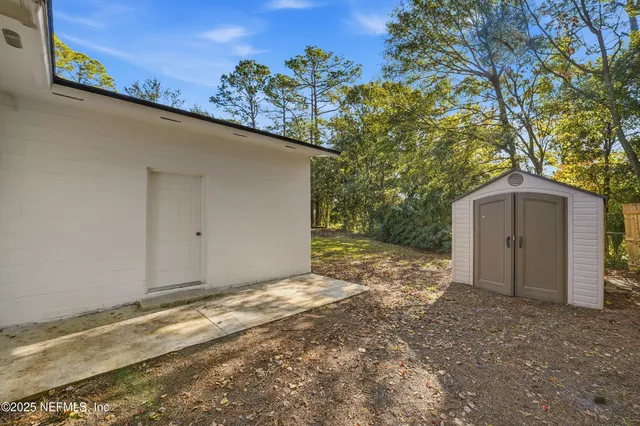 an aerial view of residential houses with outdoor space and trees