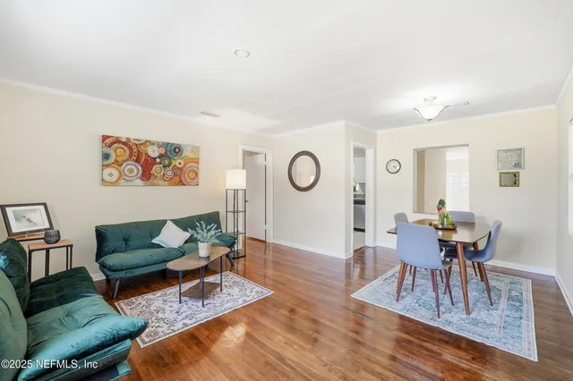 a view of a dining room with furniture a chandelier and wooden floor