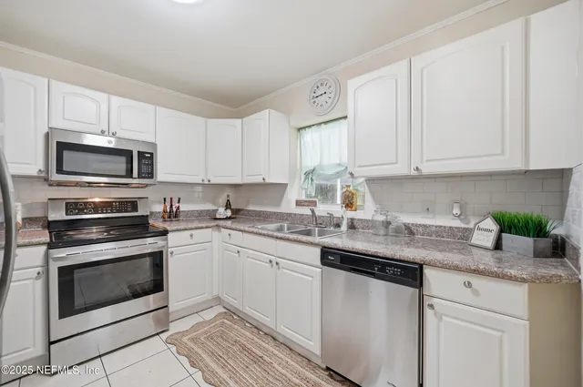 a kitchen with stainless steel appliances granite countertop a stove a refrigerator and a sink