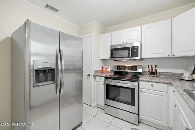 a kitchen with white cabinets and white appliances