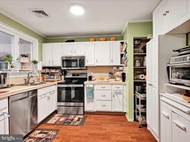 a kitchen with appliances a sink and cabinets