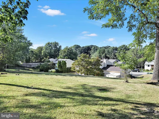 a backyard of a house with lots of green space and fountain