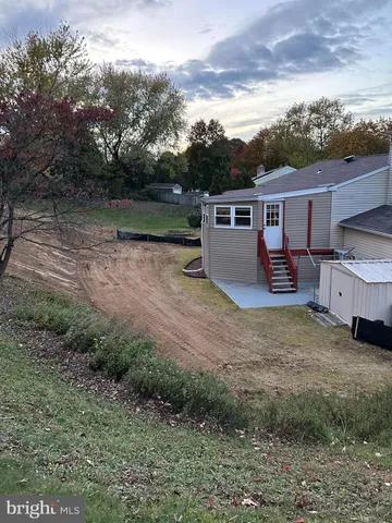 a view of a garden with a bench and trees