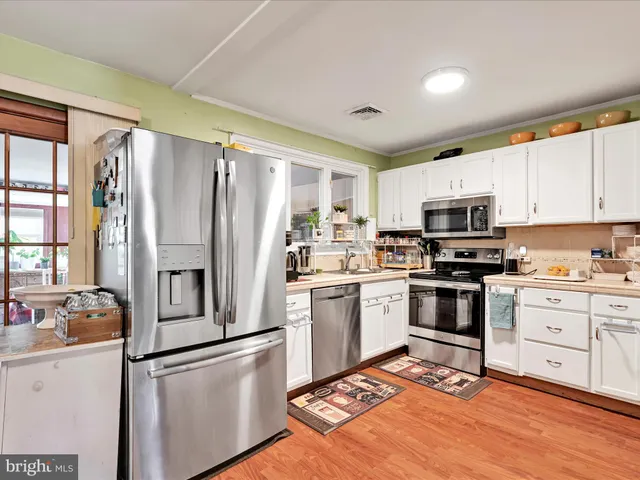 a kitchen with stainless steel appliances a stove a sink and a refrigerator
