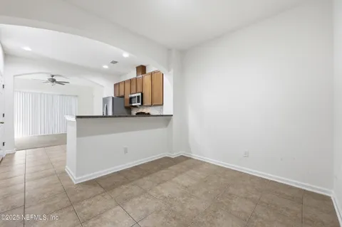 an empty room with a ceiling fan and window