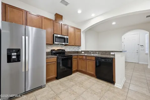 a kitchen with granite countertop wooden cabinets and stainless steel appliances