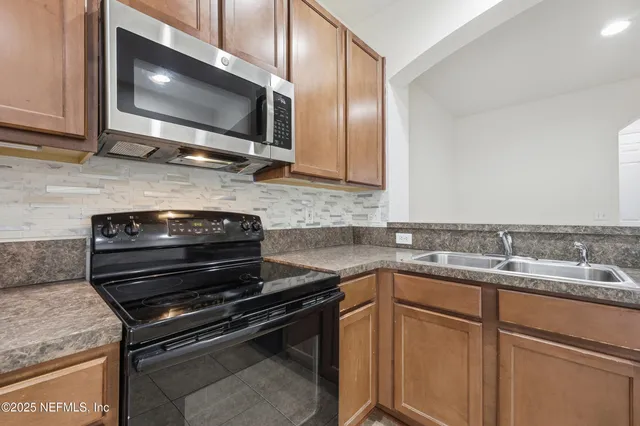 a kitchen with stainless steel appliances granite countertop a stove microwave and sink