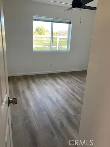 a view of a room with wooden floor and a window