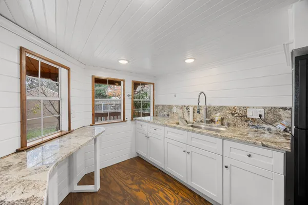 a bathroom with a granite countertop sink a toilet and shower