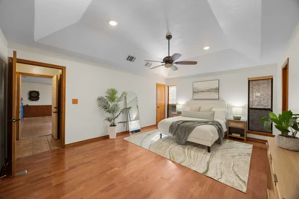 a bedroom with a large bed and a chandelier