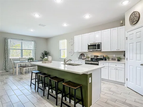 a kitchen with white cabinets and appliances