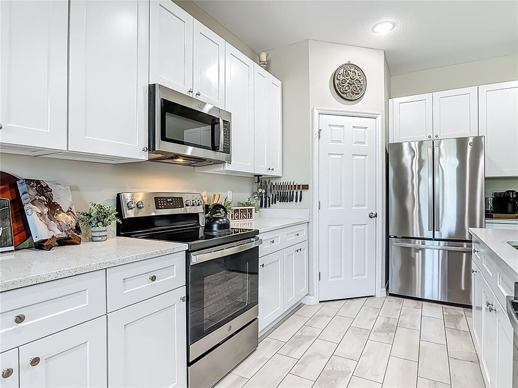 39641 Royal Trails Road Eustis, FL 32736 - Photo 16 of 63 a kitchen with white cabinets and stainless steel appliances