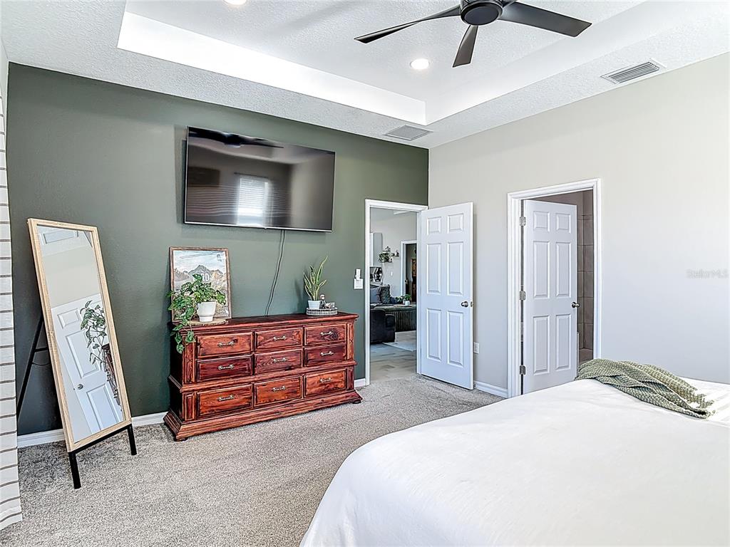 39641 Royal Trails Road Eustis, FL 32736 - Photo 28 of 57 a bedroom with a bed and a flat tv screen on dresser