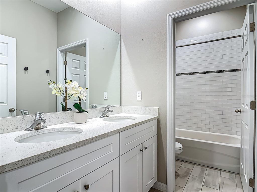 39641 Royal Trails Road Eustis, FL 32736 - Photo 43 of 63 a bathroom with a granite countertop sink a toilet and shower
