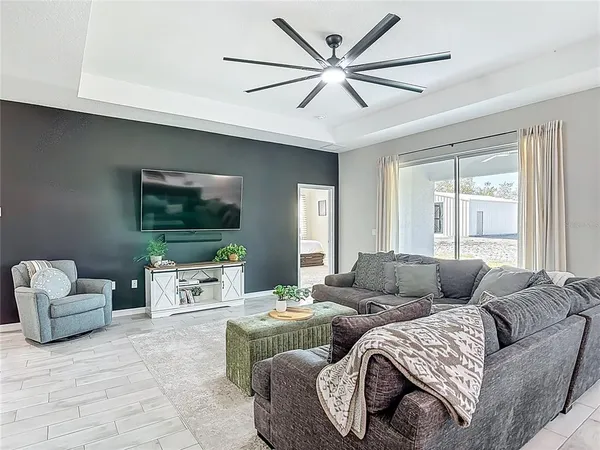 a living room with furniture and a view of kitchen